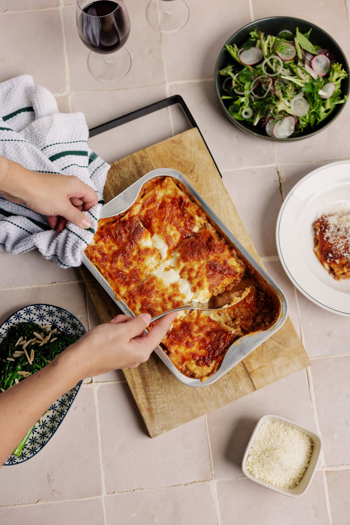 LaManna spicy sausage and vodka sauce lasagne sitting on table with vegetables