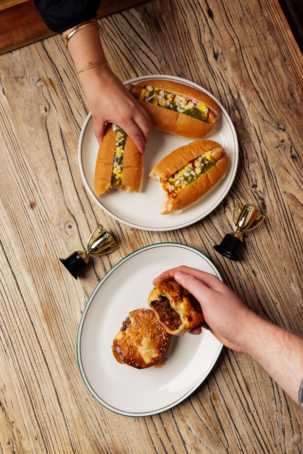 hot dogs and meat pies on a plate being eaten