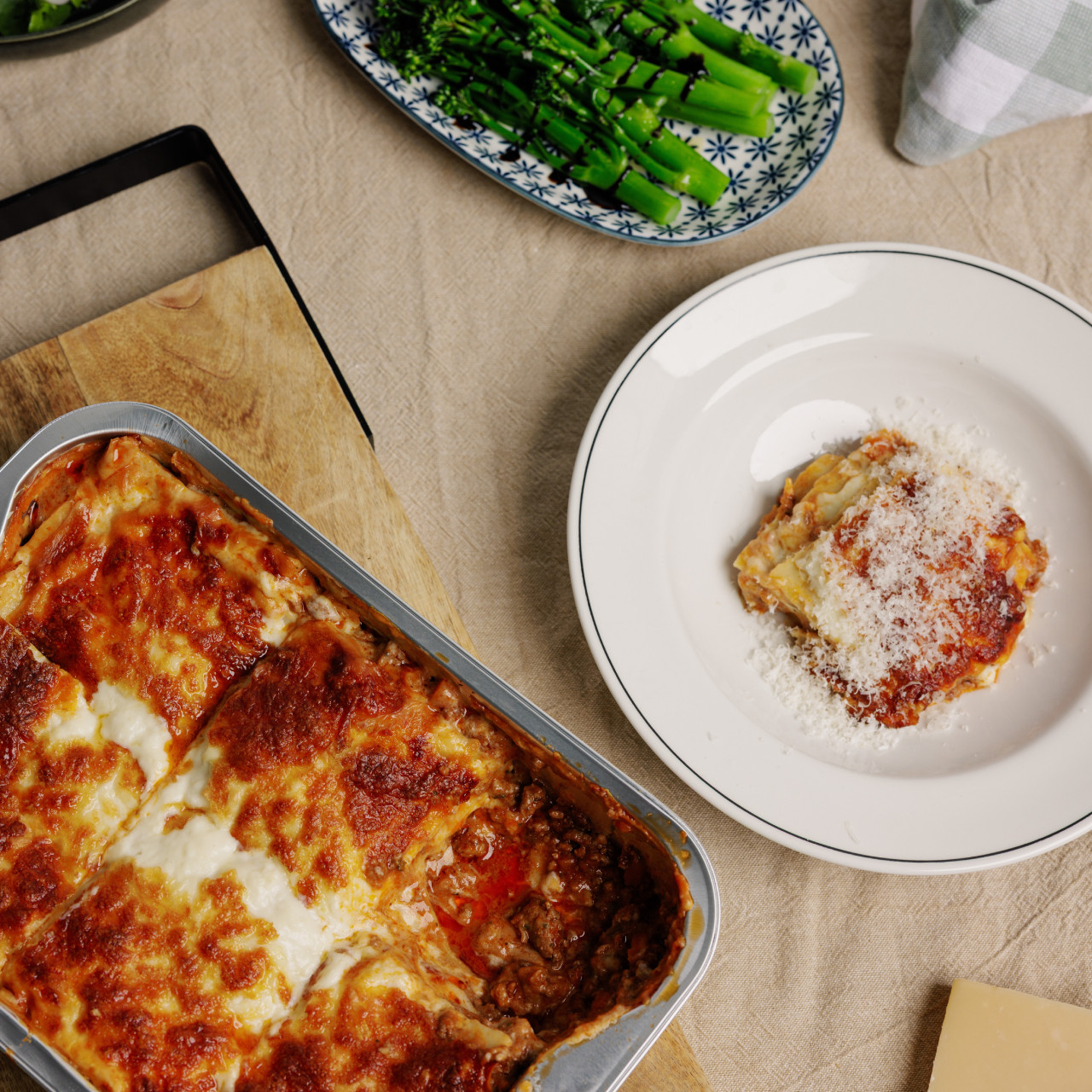 lamanna family lasagne bolognese on table in baking tray and slice on a white plate